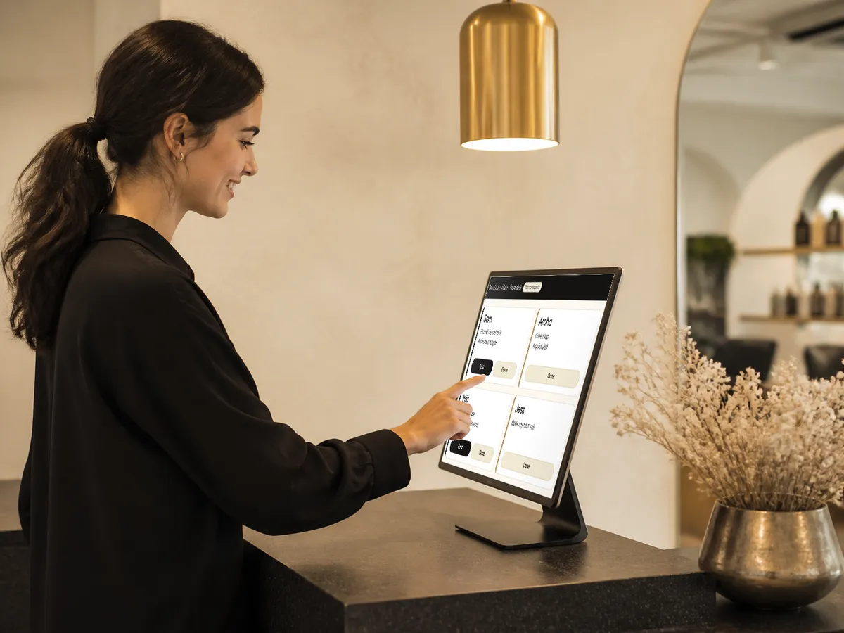 A receptionist tapping On it on the Beckon front desk screen